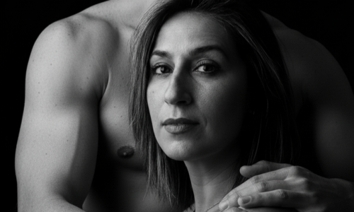 Homem abraçando uma mulher por trás, em um retrato em preto e branco, transmitindo intimidade e vulnerabilidade.